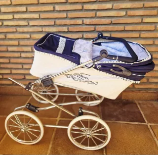 Cochecito de bebé Reborn azul y blanco.