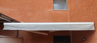Toldo eléctrico gris y blanco