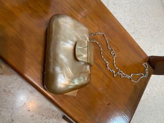 Bolso de mano dorado con cadena