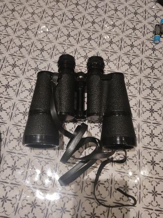 Prismáticos negros con correa y su funda.