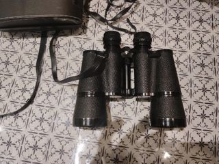 Prismáticos negros con correa y su funda.