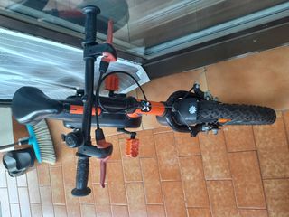 Bicicleta infantil naranja con ruedines