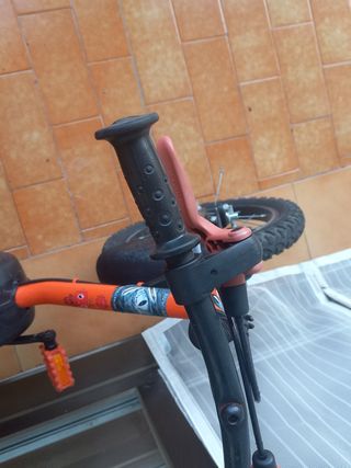 Bicicleta infantil naranja con ruedines