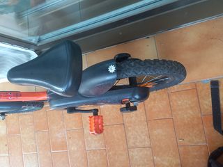 Bicicleta infantil naranja con ruedines