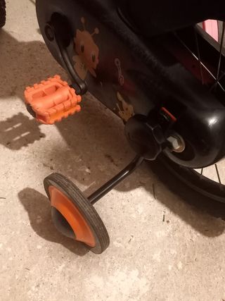 Bicicleta infantil naranja con ruedines