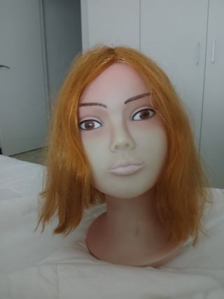 Maniquí de peluquería con pelo rojizo