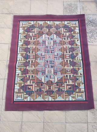 Alfombra tejida multicolor con borde rojo