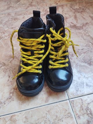 botas negras cordones amarillos