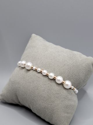 Pulsera de perlas sintéticas y detalles dorados