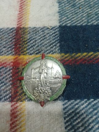 Medalla antigua con diseño de edificio y figura