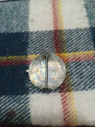 Medalla antigua con diseño de edificio y figura