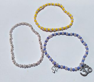 *Pulsera Morada Amarilla y Blanca con Dijes*