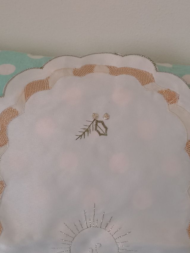 Centrotavola ricamato con candela e agrifoglio