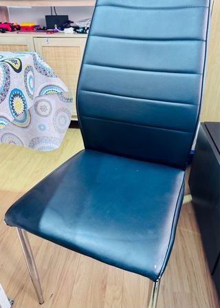 Sillas de comedor de piel sintética negra.