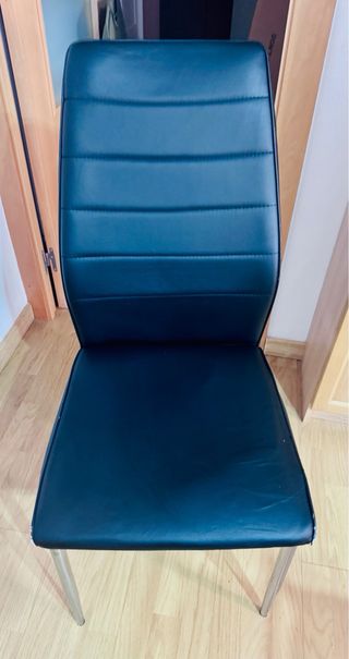 Sillas de comedor de piel sintética negra.