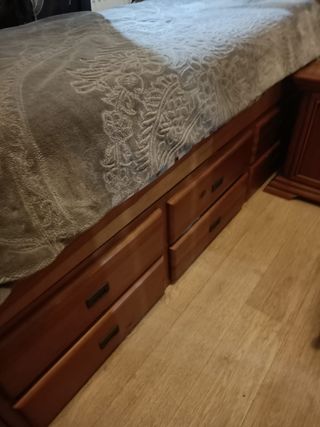Cama de madera con manta gris