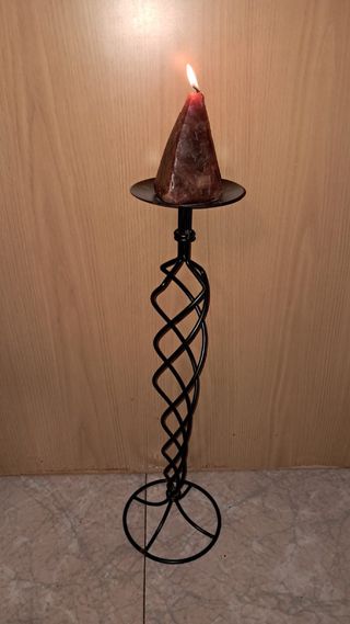 Candelabro de metal negro con vela
