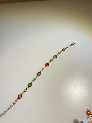 Pulsera dorada con detalles verdes