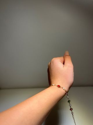 Pulsera dorada con detalles verdes