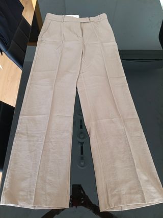 Pantalones beige y otros negros, anchos.