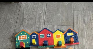 Perchero de madera con casitas de colores