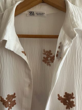 Blusa y pantalones blancos con bordado floral.