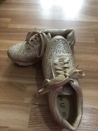 Zapatos dorados con cordones y diseño troquelado