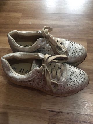 Zapatos dorados con cordones y diseño troquelado