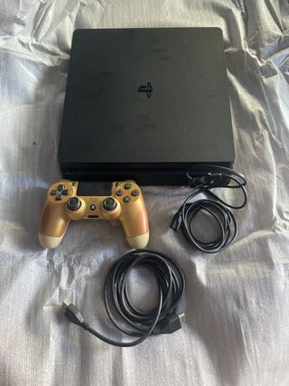 PS4 con mando dorado y cables