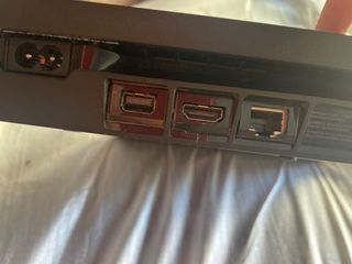 PS4 con mando dorado y cables