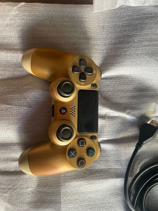PS4 con mando dorado y cables