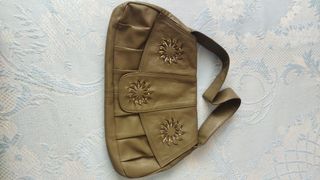 Bolso de piel con adornos dorados