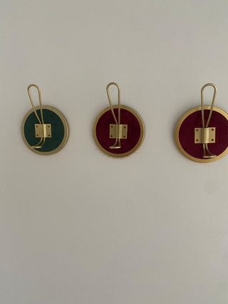 Percheros de pared dorados con base de terciopelo 