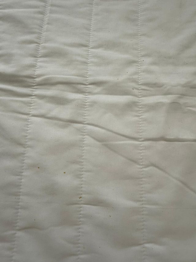 Colcha y fundas de tela grises y blancas