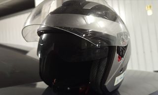 Casco de moto gris con visera