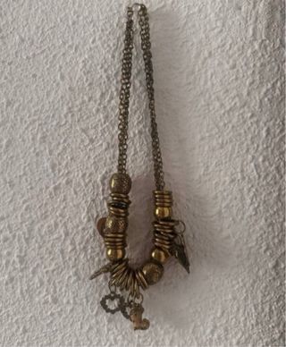 Collar dorado con multiples dijes y cuentas
