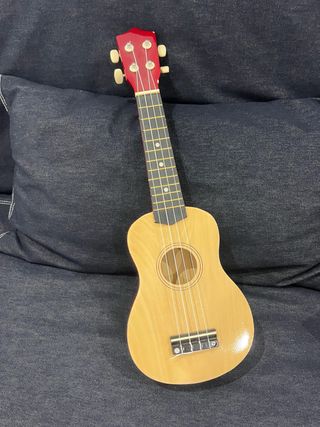 Ukelele de madera con clavijero rojo