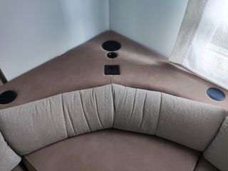 Sofá esquinero beige con sistema de audio
