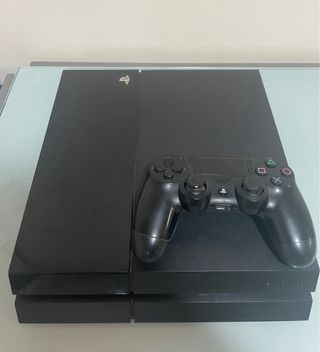 PS4 (PlayStation 4) negra con cables y mando.
