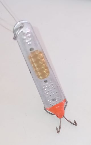 Señuelo de pesca plateado con detalles