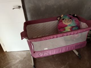 Cuna de viaje rosa con peluche de vaca