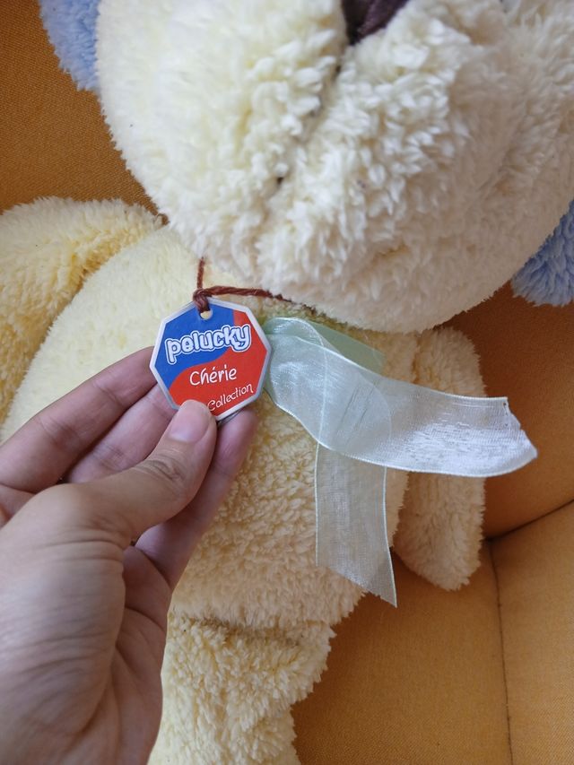 Orsetto di peluche beige con orecchie blu