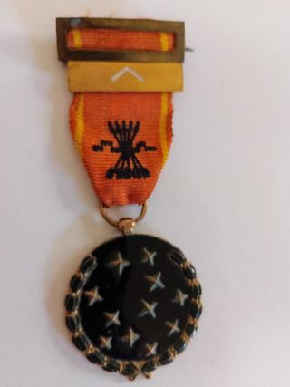 Medalla antigua con cinta naranja