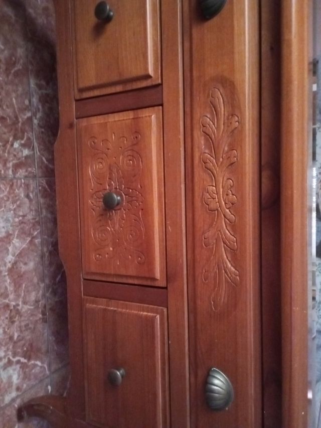 Mesa de madera con cajones y vitrina.