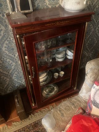 Armario de madera con detalles dorados y cristal