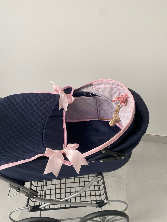 Carrito de muñecas azul con lazos rosas