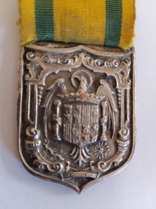 Medalla antigua con escudo y cinta