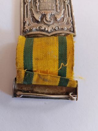 Medalla antigua con escudo y cinta