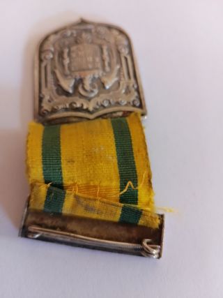 Medalla antigua con escudo y cinta