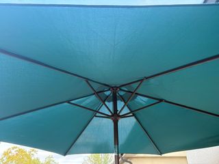 Mesa de terraza verde y sombrilla